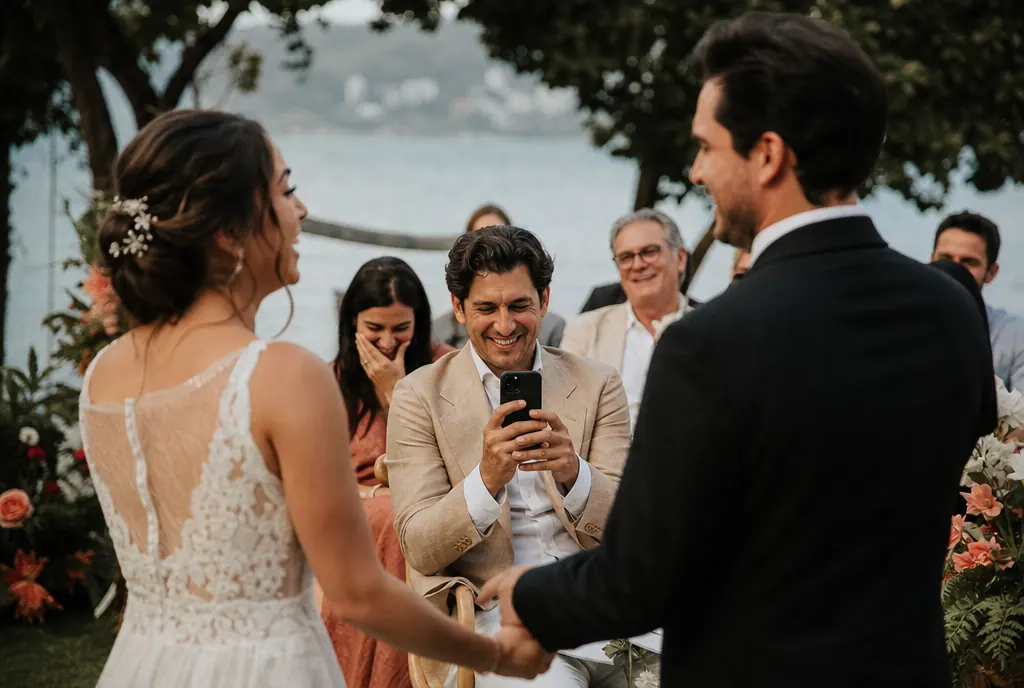 Wedding photographer kneeling in the aisle during a garden ceremony